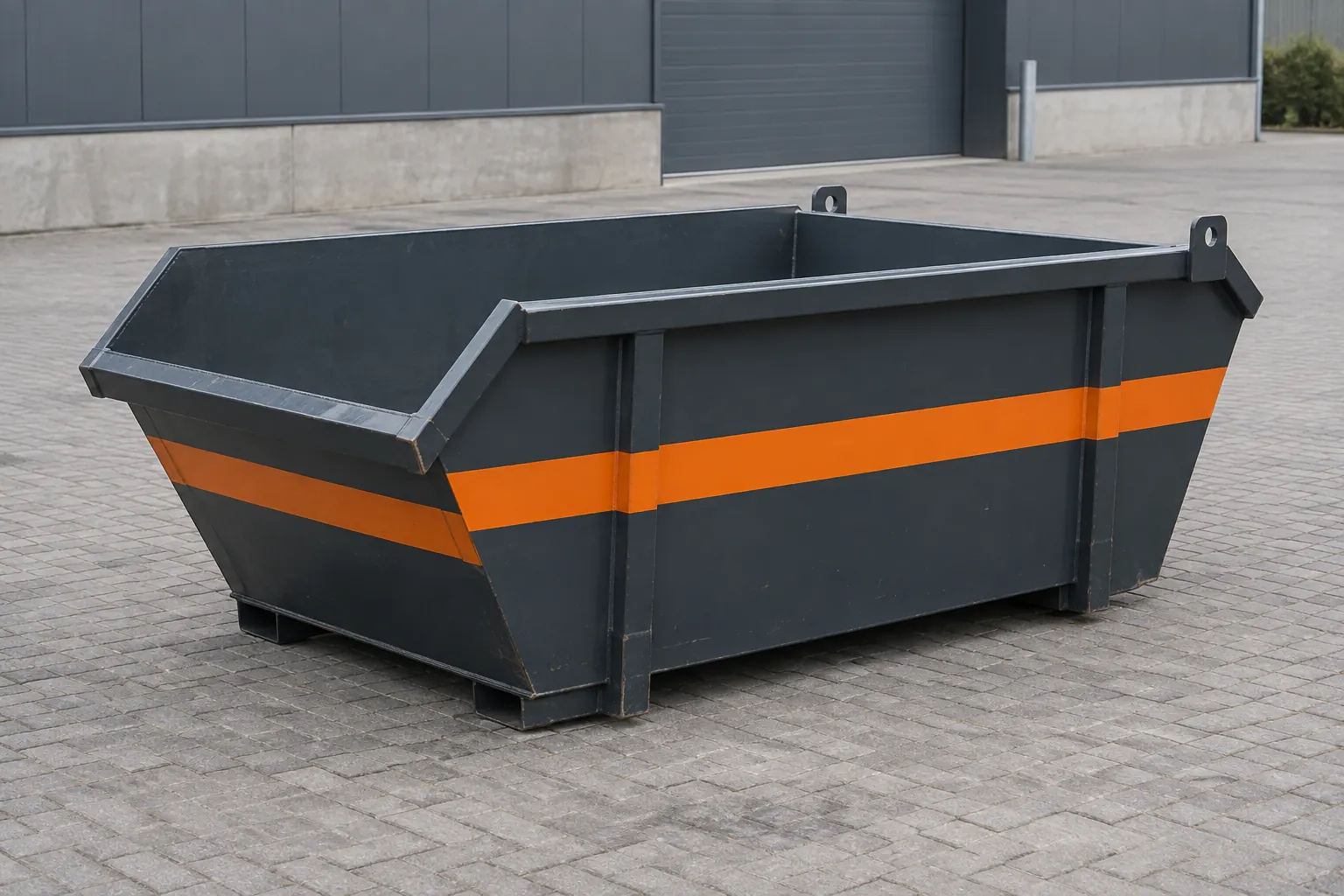 Kleine antraciet container van 3 m³ met oranje streep op een bestraat terrein